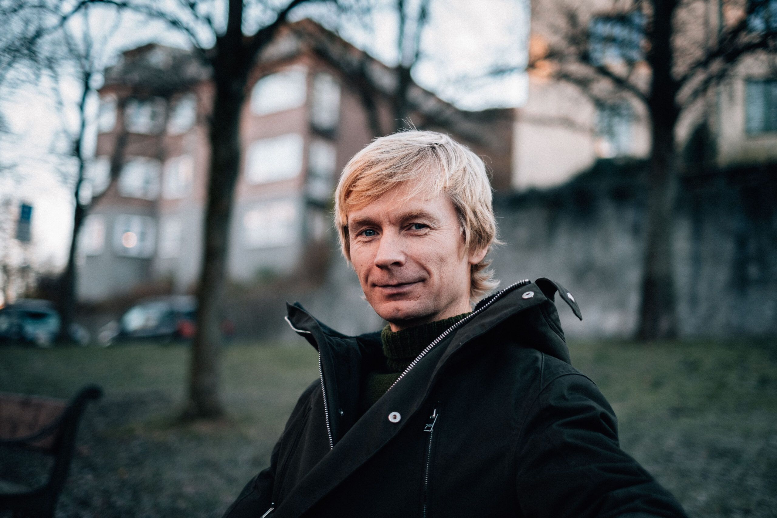 Miljøsjef i Vinmonopolet sitter på en benk ute