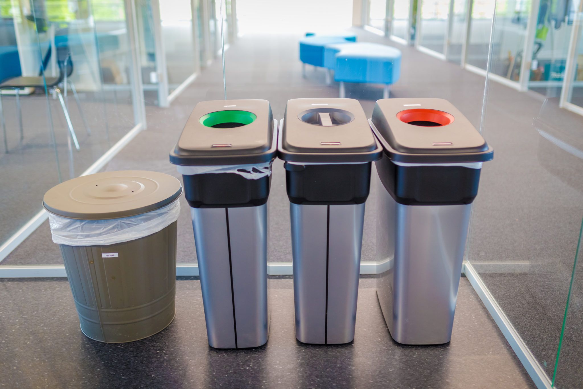 Bildet viser tre avfallsdunker plassert i kontorlandskap