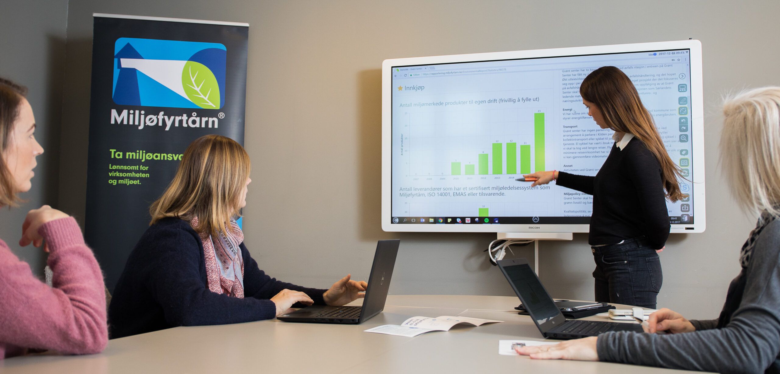 Dame som peker på graf på skjerm Dame som peker på graf på skjerm