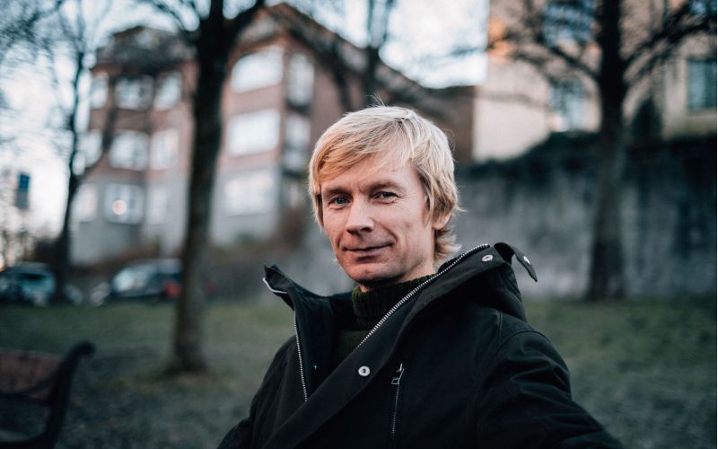 Miljøsjef i Vinmonopolet sitter på en benk ute