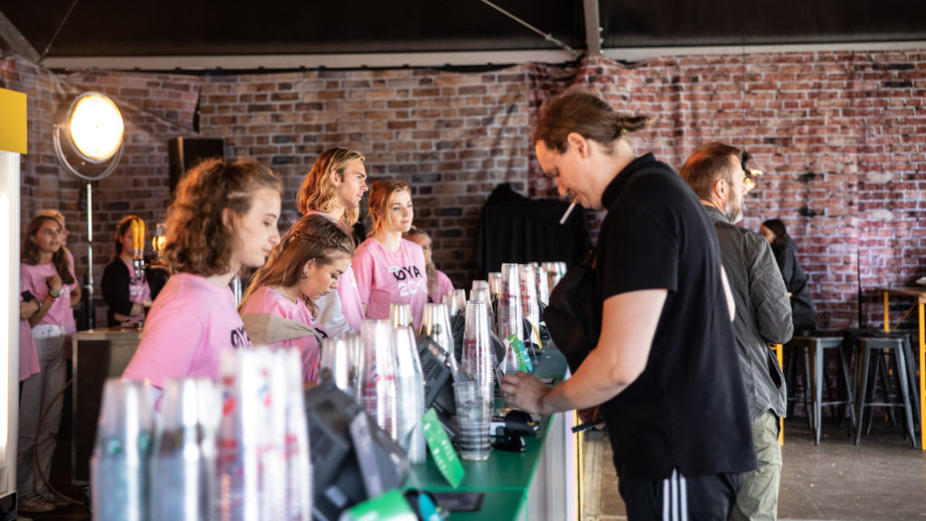 Bardisk med plastglass og servitører og frivillige