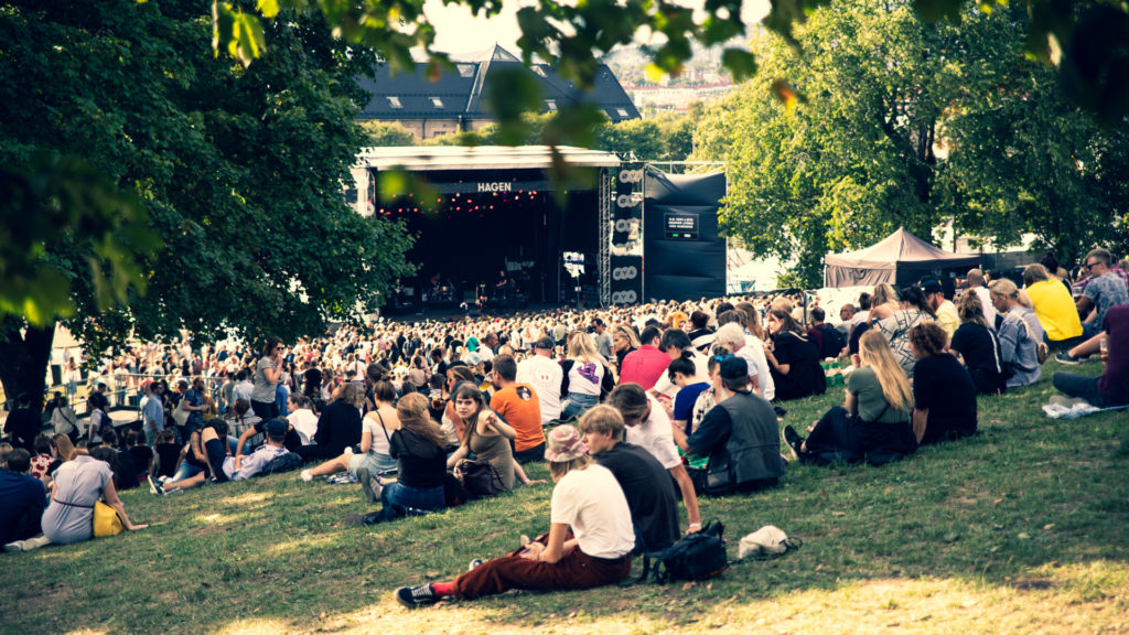 Konsertscene og mennesker som sitter på plen